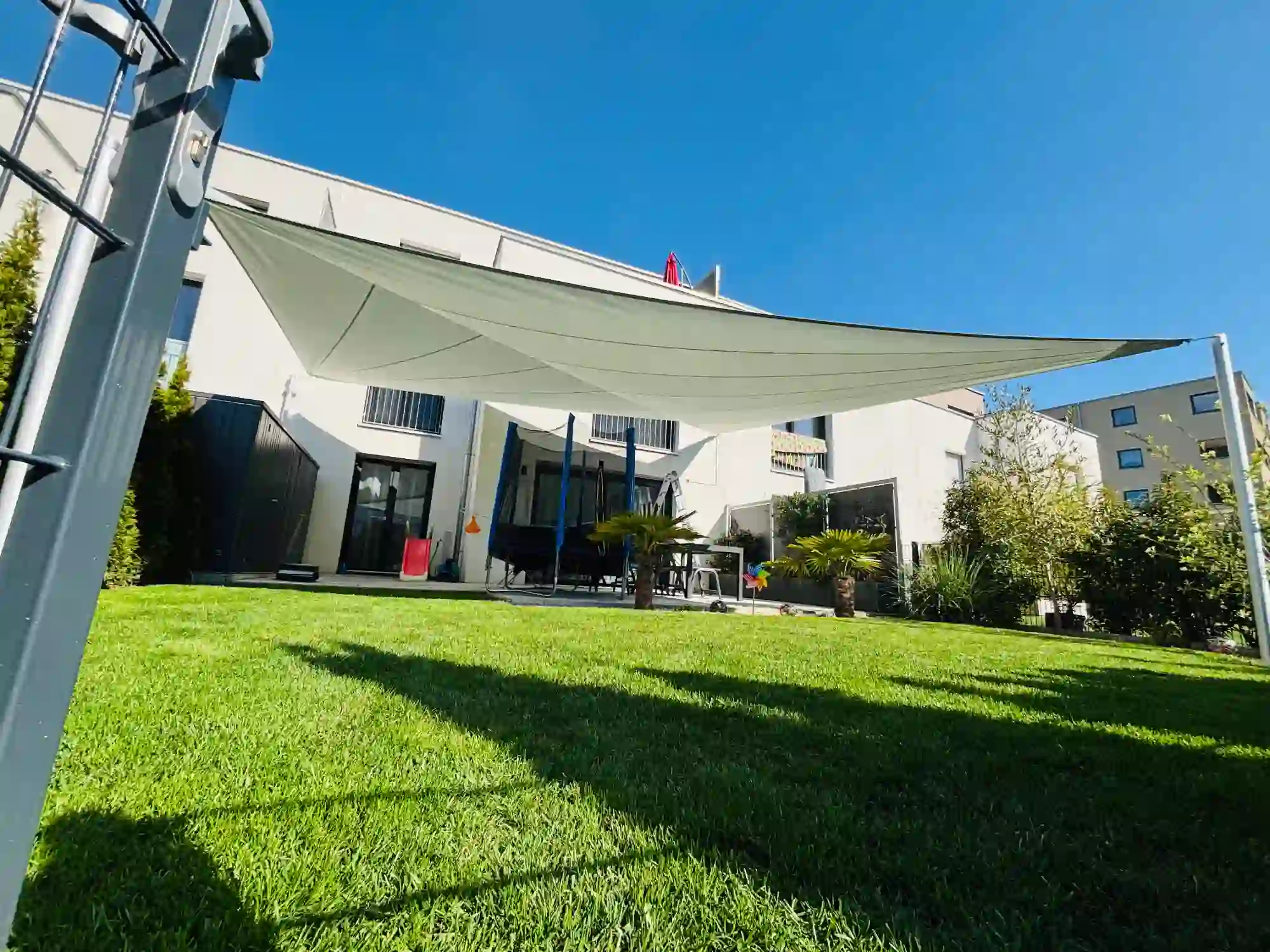 Sonnenschutz über einem grünen Garten.