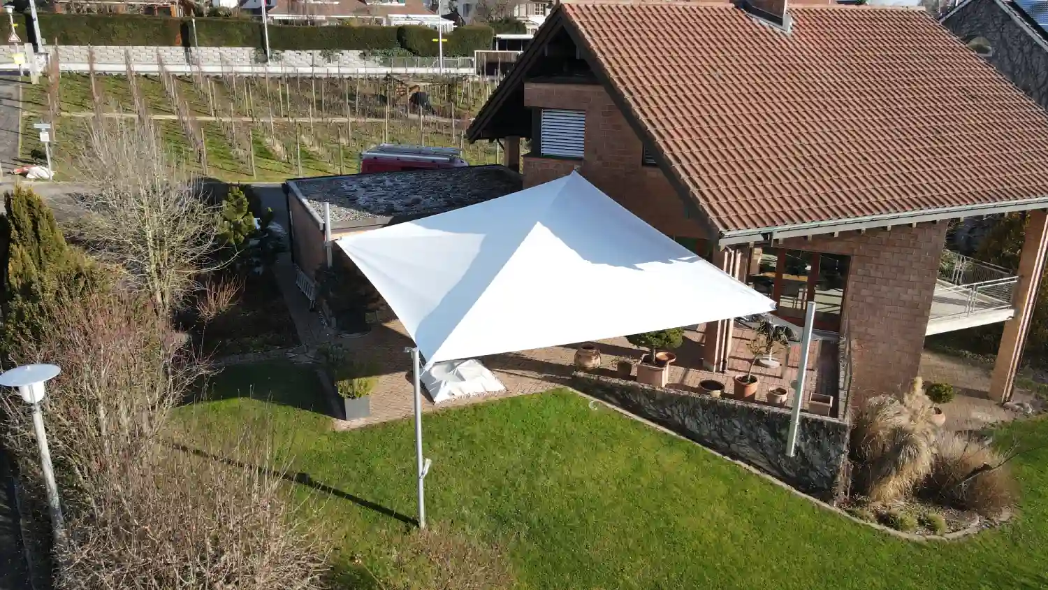 Weißer Sonnenschutz über dem Garten.