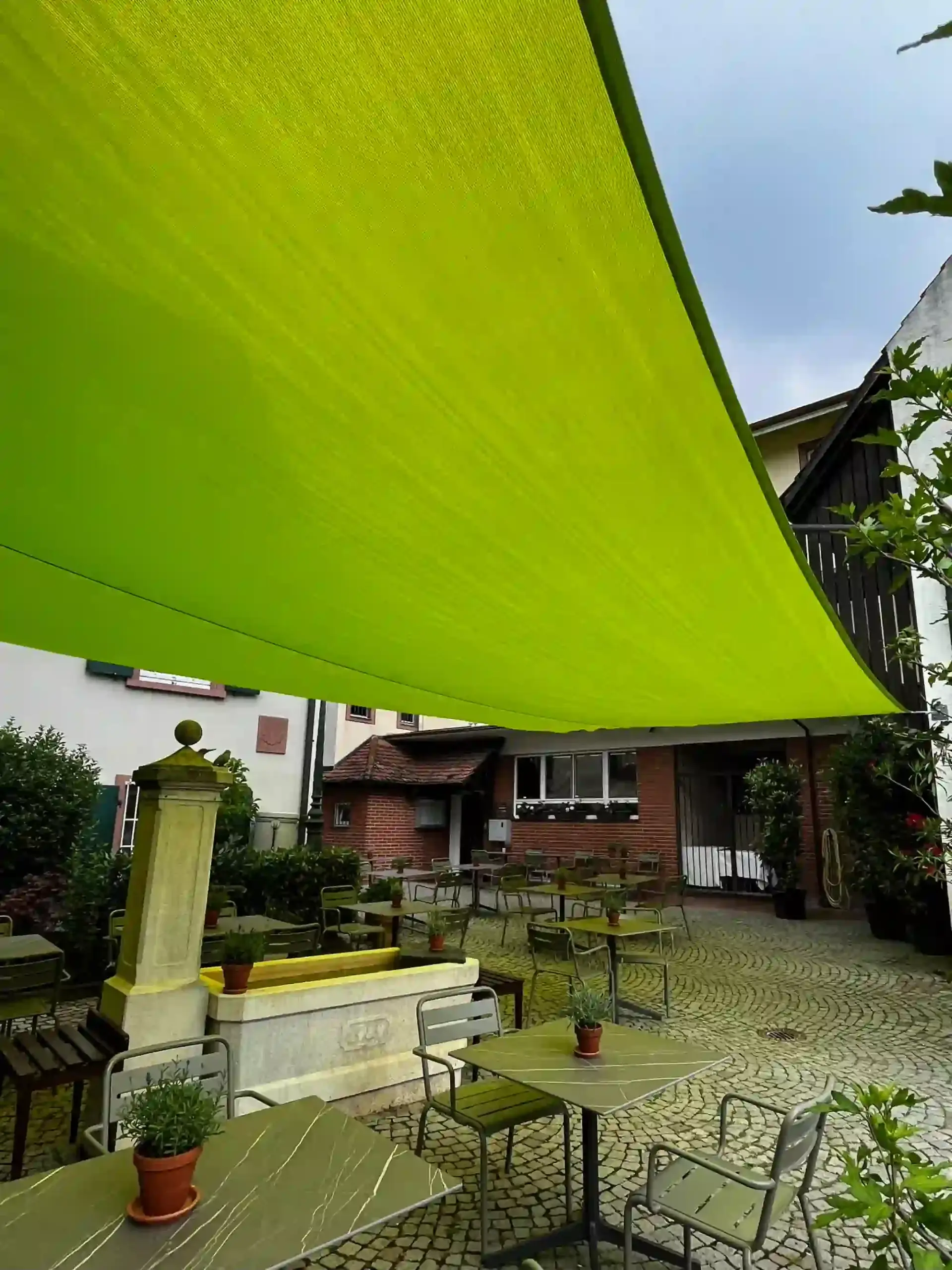 Grünes Sonnensegel über einer Terrasse