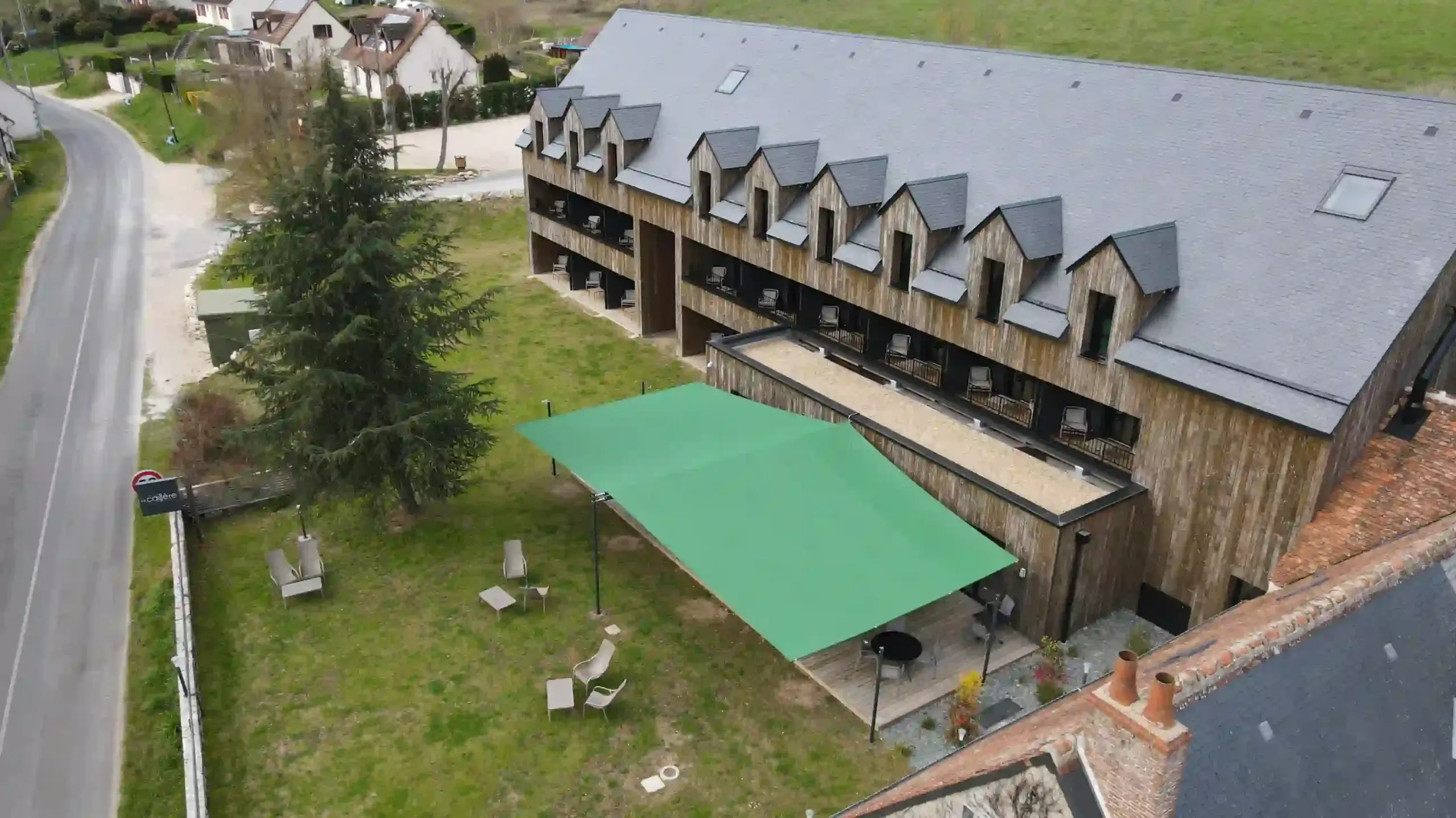 Moderne Holzunterkunft mit grüner Überdachung.